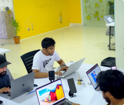 Équipe de développeurs et designers travaillant sur des projets web dans une agence digitale, entour