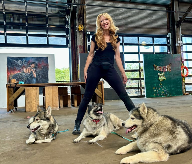 Trainer Julie standing in front of her three dogs