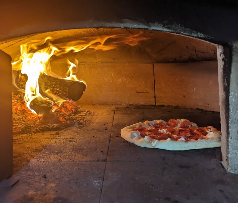 wood fired pizza oven cooking a pizza