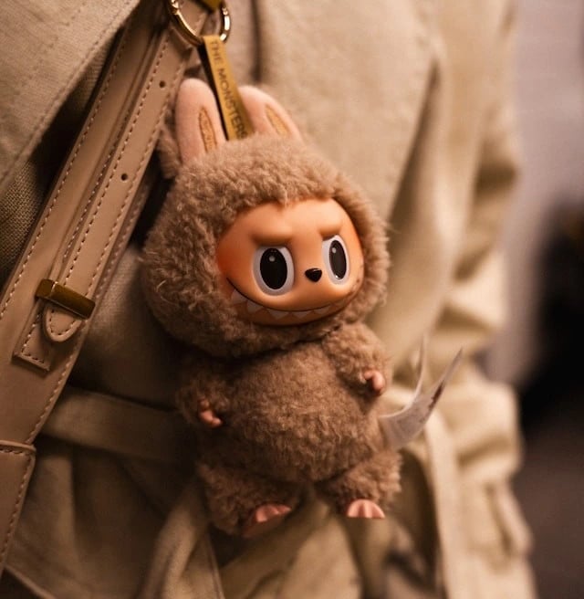 Labubu plush keychain handing from a backpack