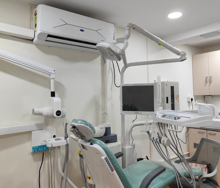 Modern dental clinic room with an adjustable green examination chair and medical imaging equipment.