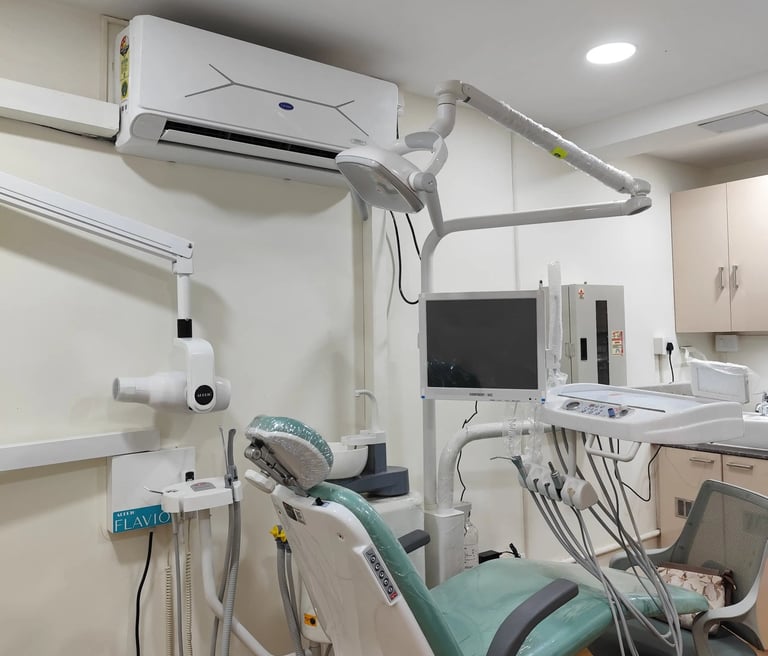 Modern dental clinic room with an adjustable green examination chair and medical imaging equipment.