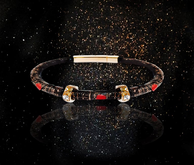 Luxury designer bangle bracelet with gold accents and red details on a black glitter background.