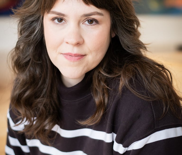 Headshot of young woman wearing a striped sweater.