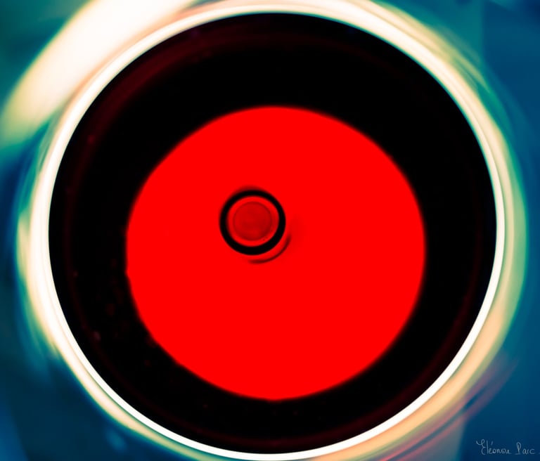 Abstraction Vinicole – Verre de vin vu du dessus, disque rouge et anneaux lumineux