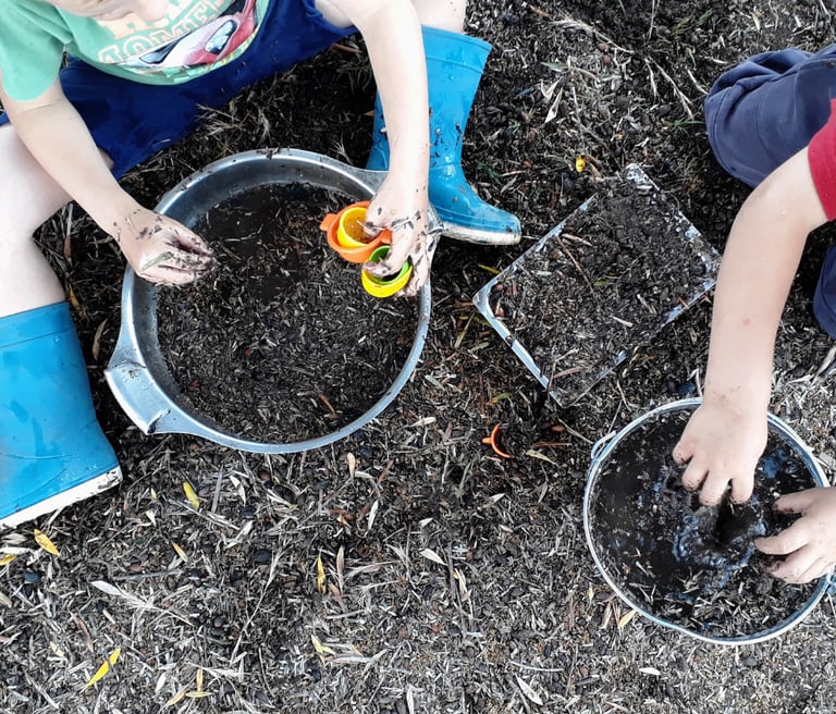 children playing in the dirt with loose parts