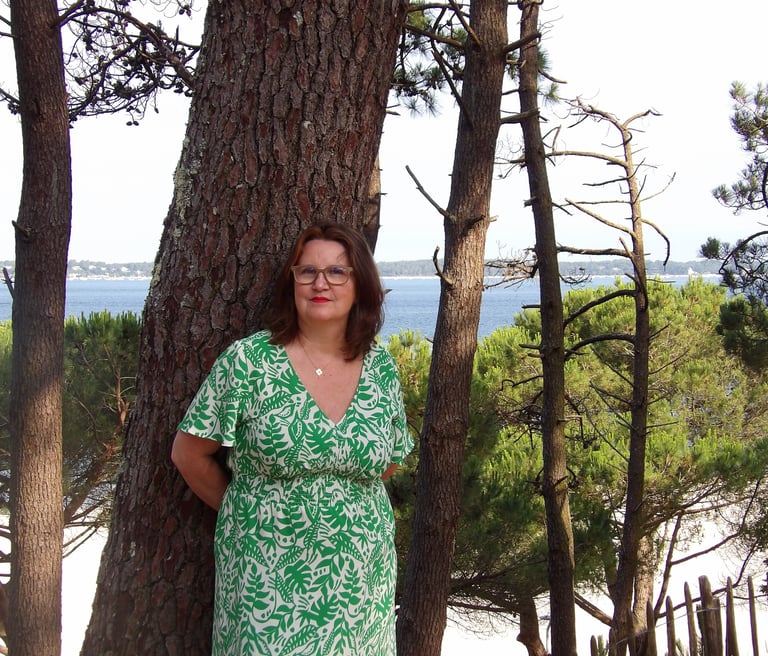 sophrologue spécialisée près des arbres face à la mer, reflétant une approche humaine