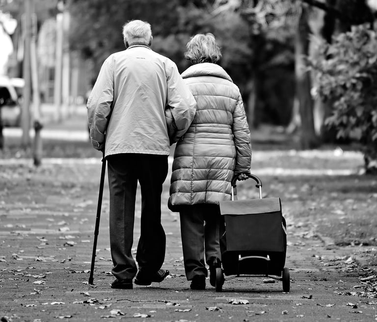 Couple growing old together walking arm-in-arm. 