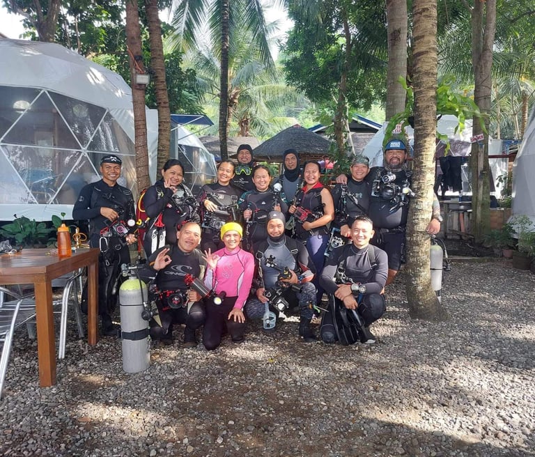group of scuba divers, happily posing going into the dive in Dauin, Negros, the muck diving capital 