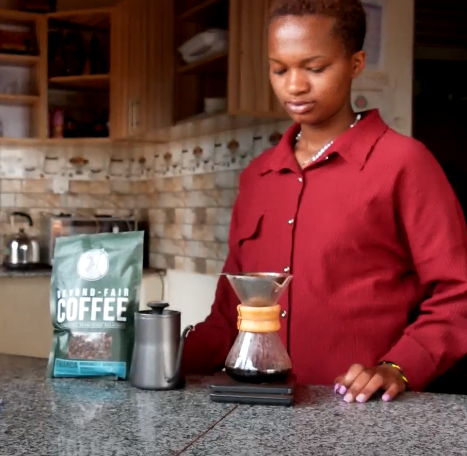 a woman in a red shirt is holding a coffee pot