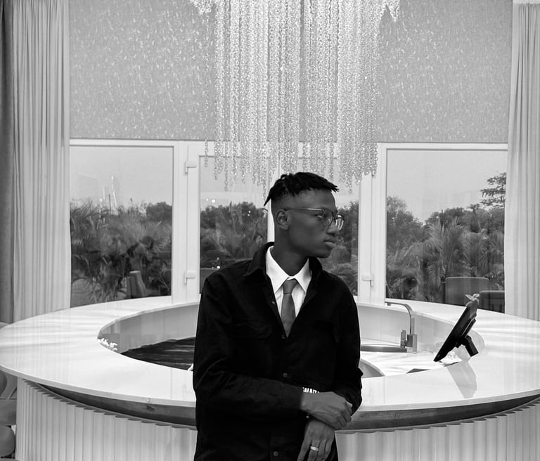 reed in a suit and tie standing in front of a bar