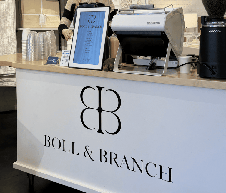 Barista preparing latte at custom branded mobile coffee cart for Boll & Branch corporate event in Dallas