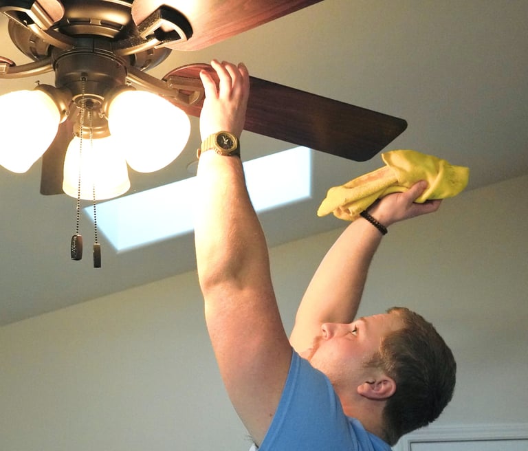 Cleaner from Chez Cleaning Services cleaning a ceiling fan in a house