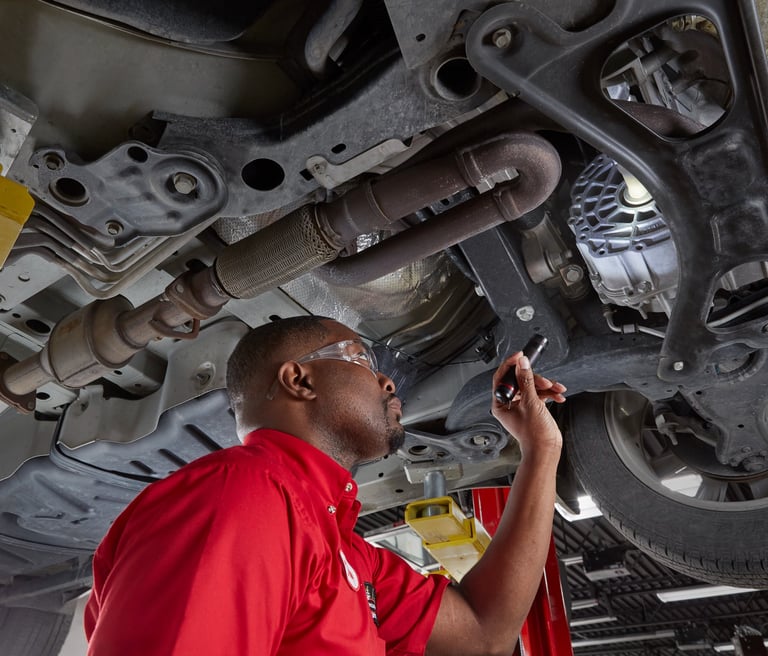 A Big O Tire employee inspecting a car