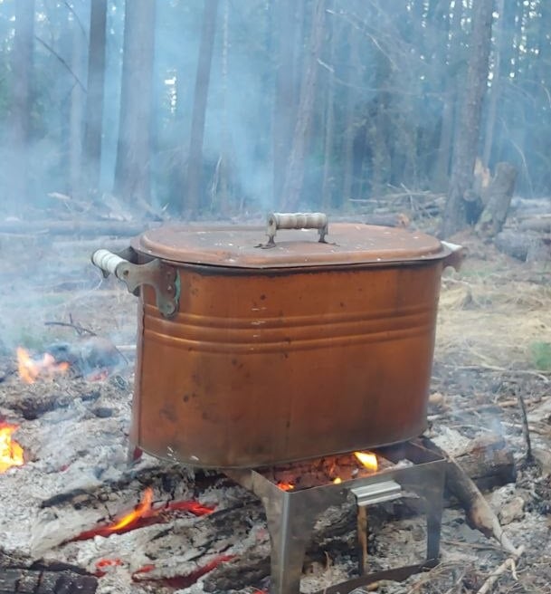 A vintage copper boiler pot used for natural dying in the forest.