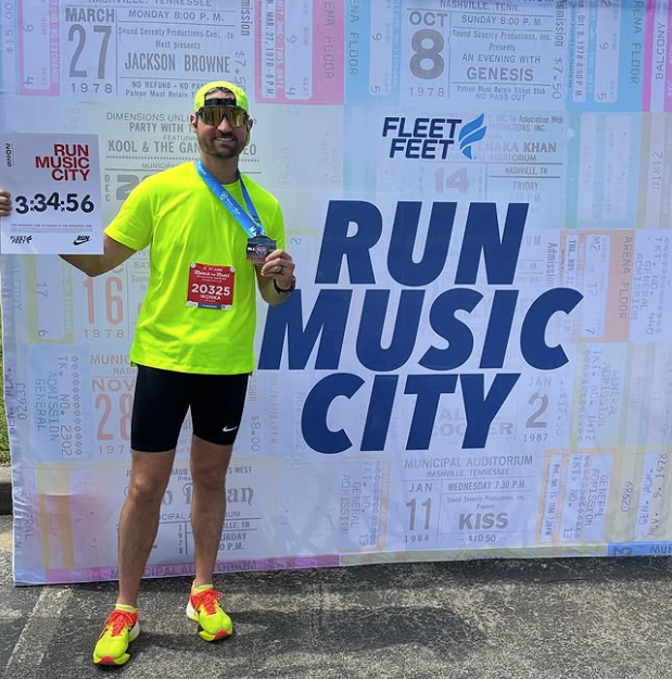 a photo of the owner of Race Ready events standing in front of a wall for the Nashville Marathon