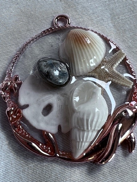 Resin pendant, colored gold with small seashells and a sand dollar