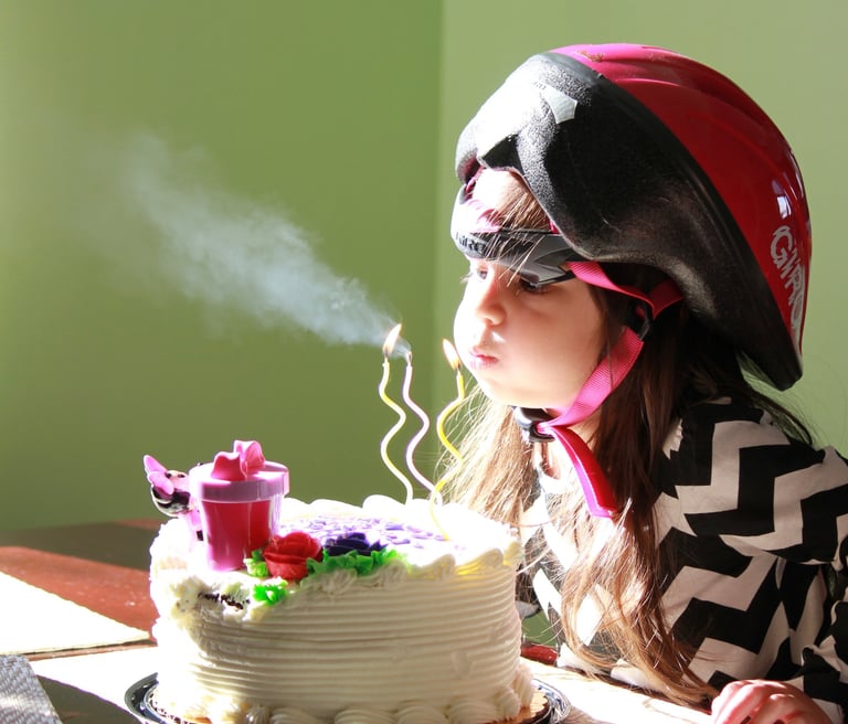 a young girl blowing out birthday candles