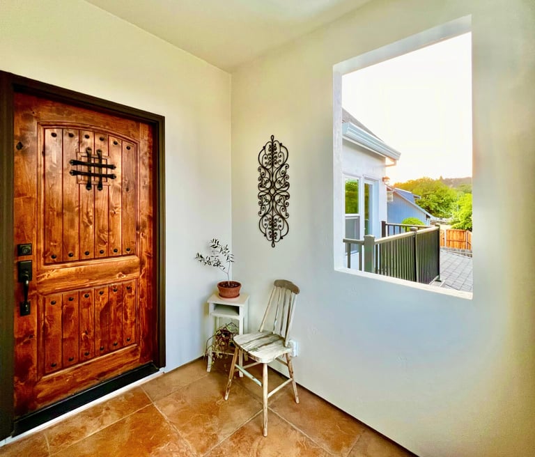 Welcoming entryway with a warm stained wood door and seating area.