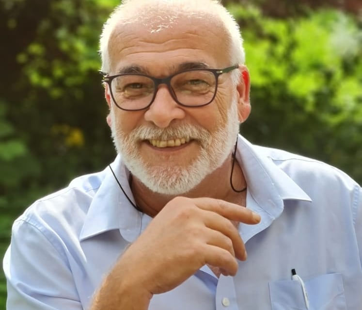 Patrick Beiner with a beard and glasses sitting in a chair