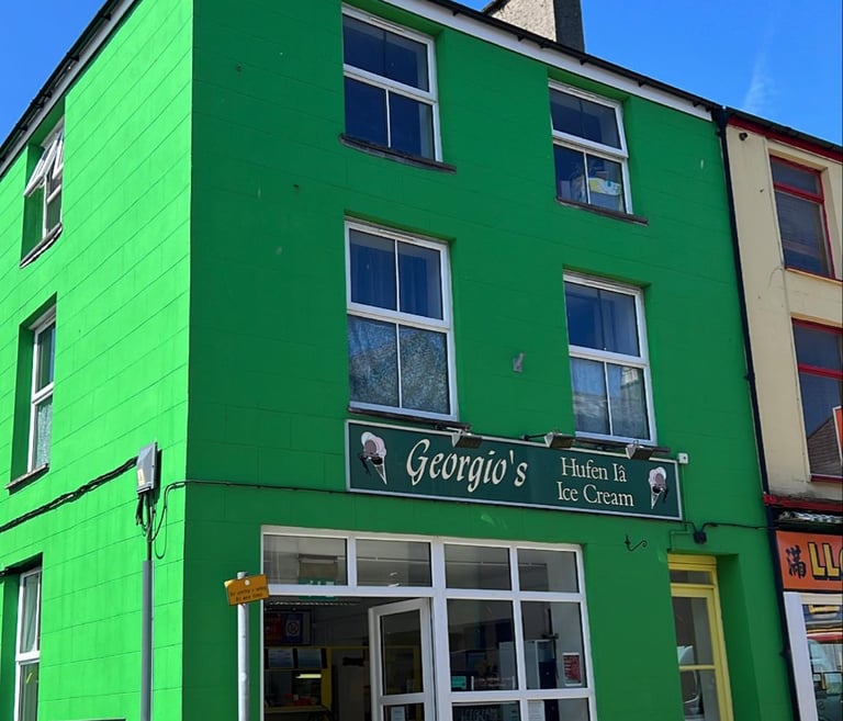 Georegio's shop front. Prominent green building in Llanberis High Street.
