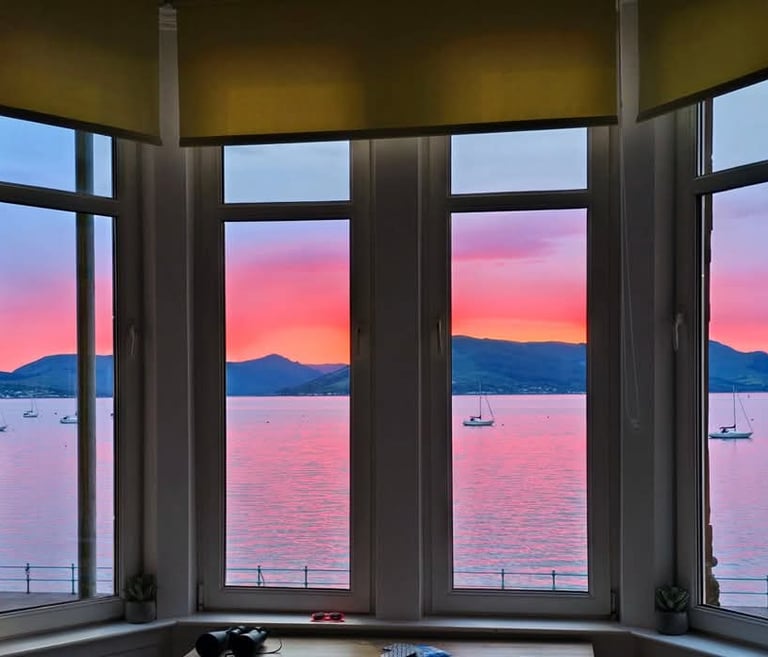 View from the window at at Gourock Seaview Holiday Let with a view of the ocean and sunset