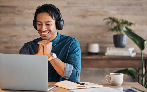 a man wearing headphones and headphones, sitting at a desk with a laptop Telehealth 
