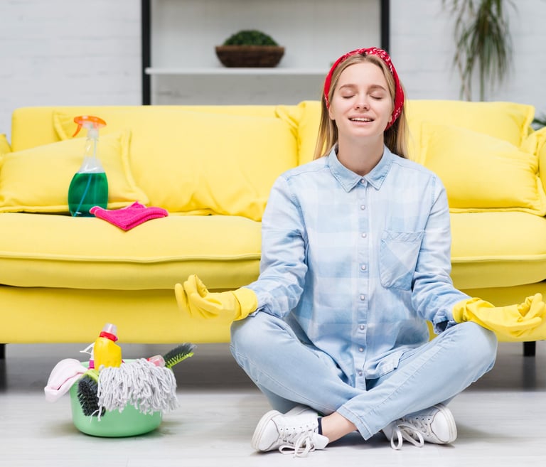 a woman sitting on a couch with a cleaning mop after a great clean services