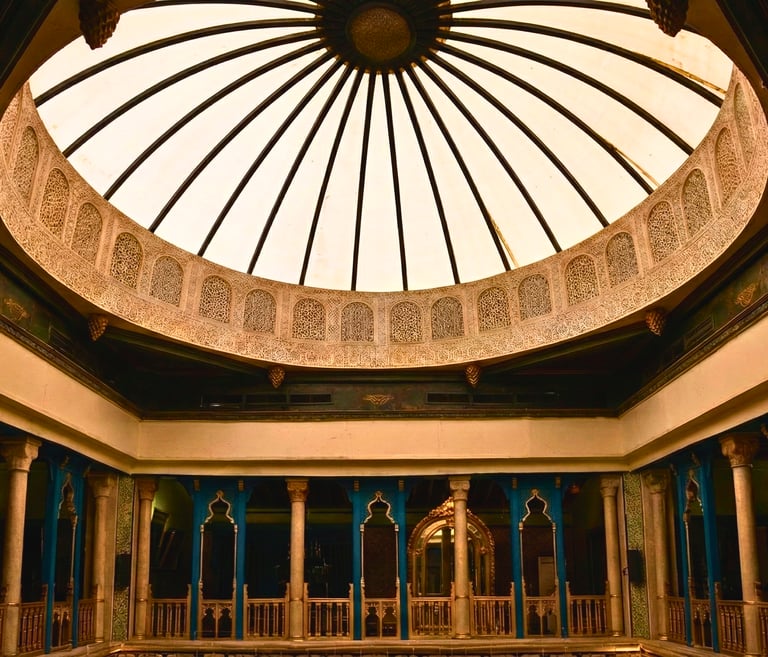 Vue intérieure de la coupole ornée de plâtre sculpté et des arcades en bois bleu d'architecture arab