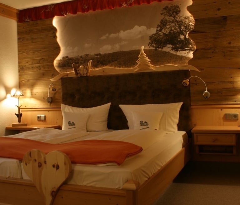 Hotelzimmer mit liebevollen Holzdetails in der Köhlerhütte Fürstenbrunn