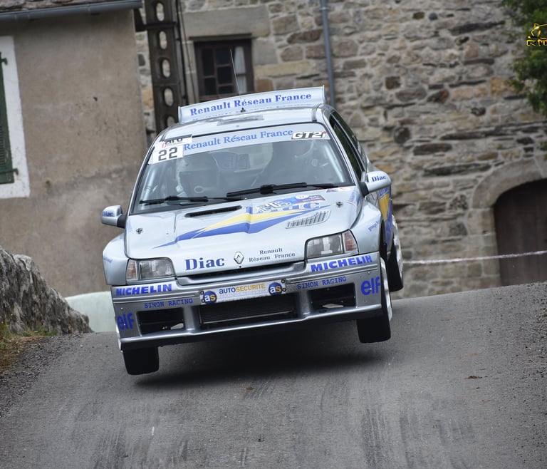 Une Renault Clio Maxi aux couleurs d'origine "diac" en plein saut lors du rallye de Bagnols les Bain