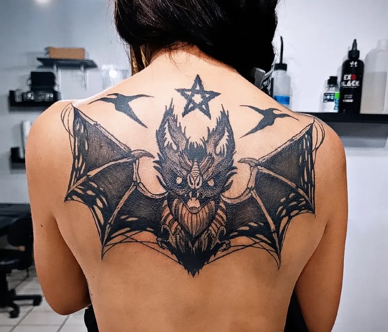 a woman with a bat - like tattoo on her back