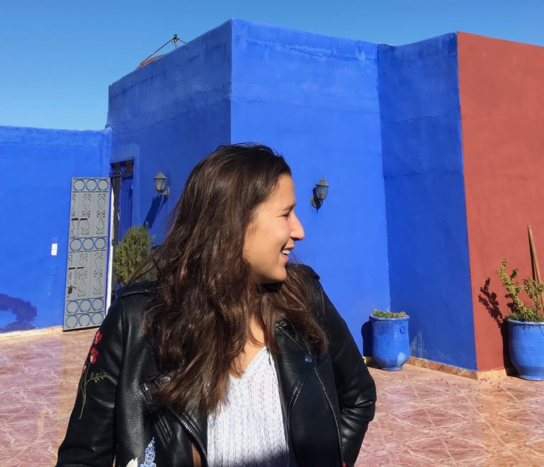 Guide touristique souriante, devant l’architecture marocaine aux couleurs éclatantes.