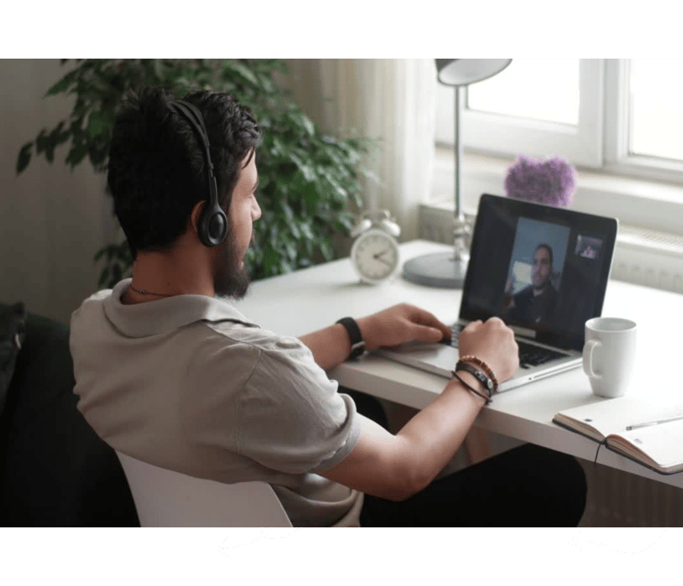 a man sitting at a desk with a laptop computer