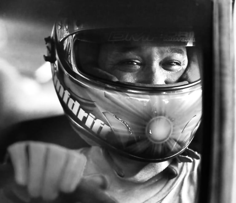 Close-up of a race car driver with a race helmet on inside a car