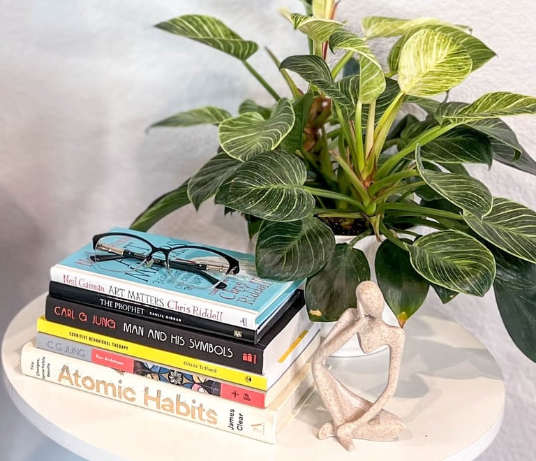 an end table with books and a plant
