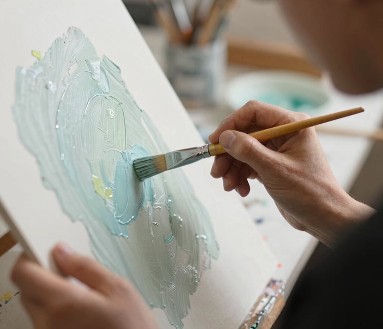 Un artista aplicando pintura acrílica azul claro texturizada sobre un lienzo con un pincel.