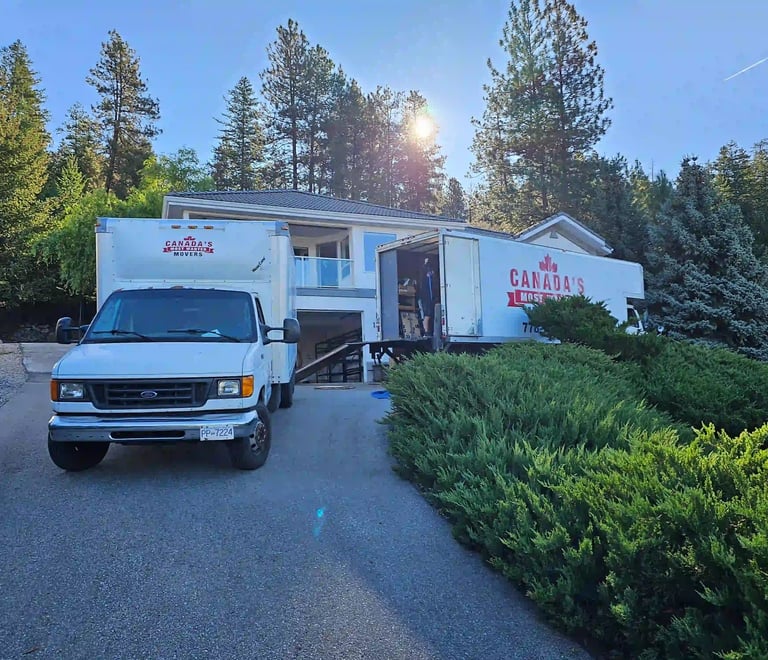 Canada’s Most Wanted Movers trucks loading at a hillside residential property in the Lower Mainland.