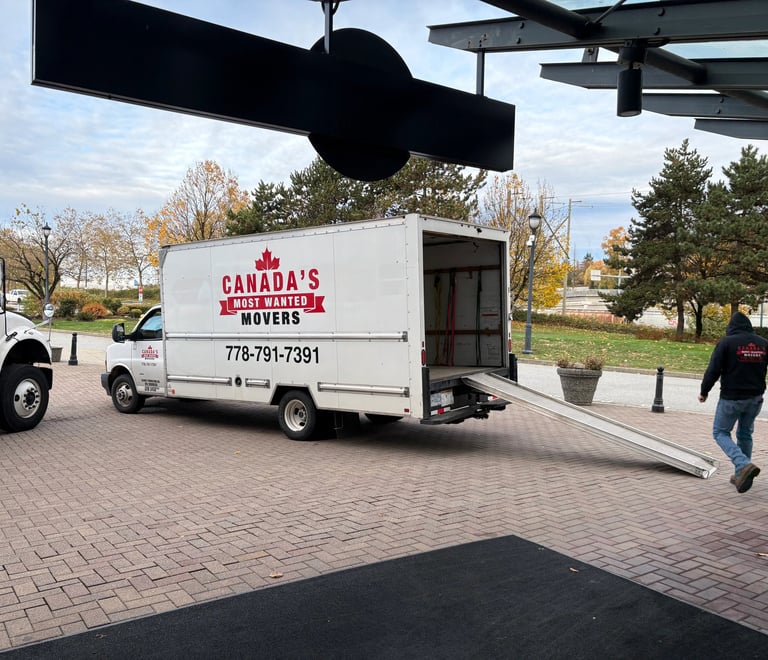 Canada’s Most Wanted Movers unloading at a commercial property in Coquitlam with ramp extended.