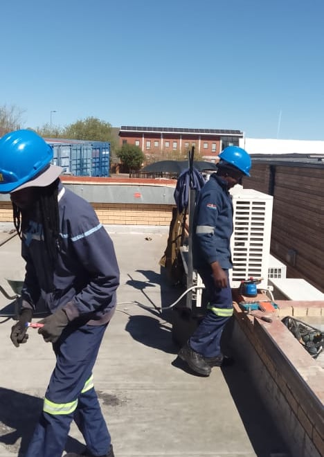 EPC roof repair team preparing surface on commercial flat roof in Bloemfontein