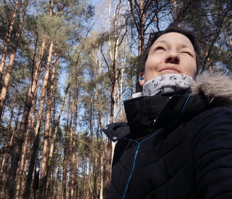 Tonia in a black jacket and a bicycle, in the woods
