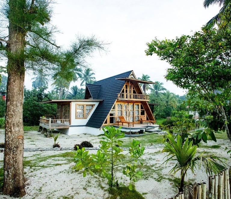 a house with a triangle shaped roof and a wooden fence