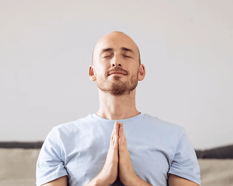 man with hands together, finding inner peace and starting to heal his mind