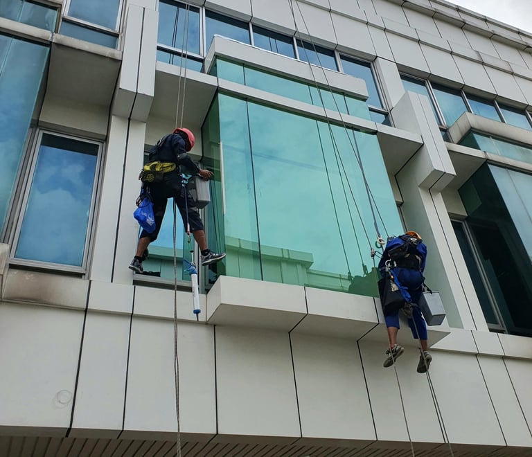 two men are hanging from a building while another man is hanging off the side of