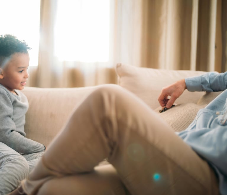 a man sitting on a couch with a child