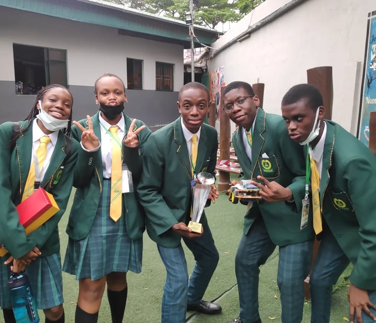 a group of youth holding a trophy and robot