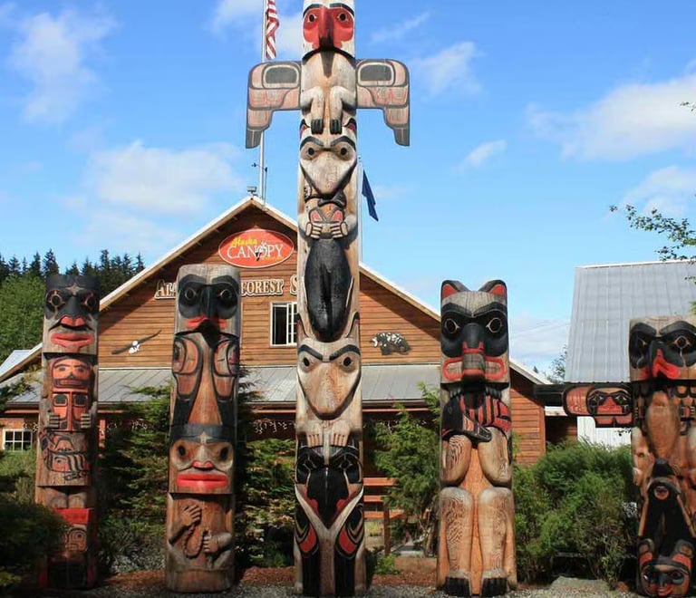 Hand-carved Alaskan totem poles standing outside the Herring Cove Rainforest Sanctuary in Ketchikan.