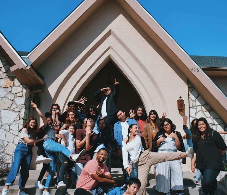 a group of people standing around a man in a suit and tie