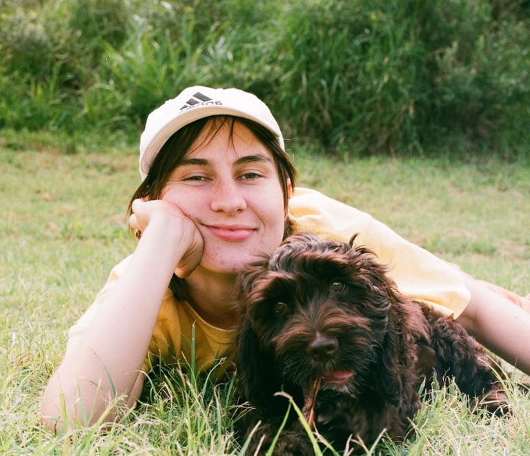 an image of the mediator laying casually on the grass with her dog