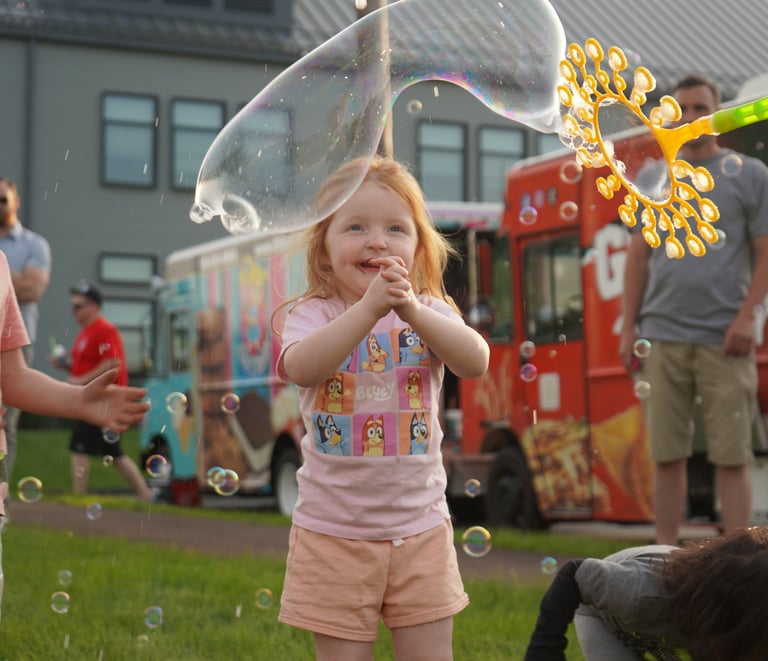 Little girl claps at the bubbles